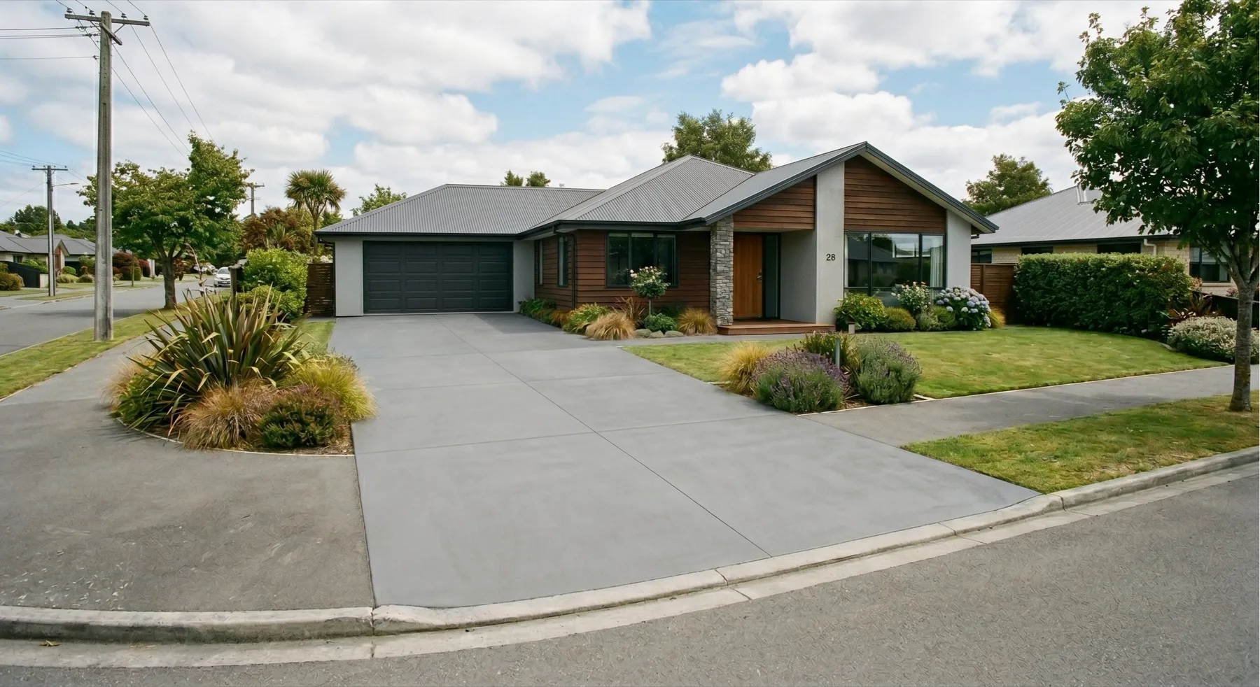 Newly finished concrete driveway in front of a modern Canterbury home